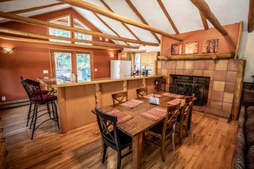 a dining room with a table and a fireplace at Colorado Bear Creek Cabins in Evergreen