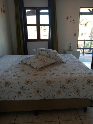 a bed with two pillows on it in a bedroom at Suítes Novo Amanhecer in Sao Jorge