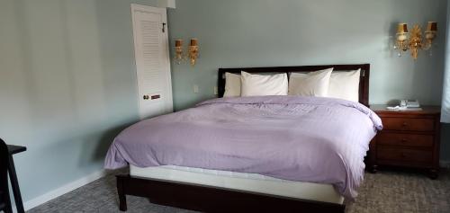 a bedroom with a bed with a purple comforter at Lowell Inn in Stillwater