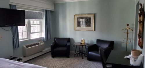 a room with a bed and two chairs and a table at Lowell Inn in Stillwater