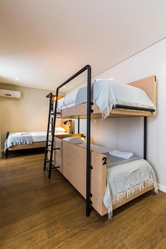 a room with two bunk beds and a ladder at Gallery Hostel in Porto