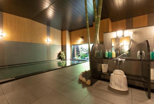 a bathroom with a swimming pool next to a swimming pool at Hotel Route-Inn Osaka Kishiwada -Higashikishiwada Ekimae Kansai Airport- in Kishiwada