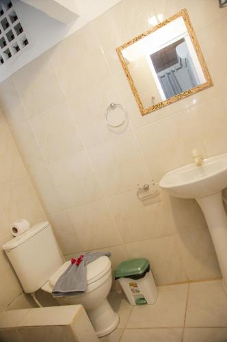 ein Badezimmer mit Toilette, Waschbecken und Spiegel in der Unterkunft Pousada Jerimar in Jericoacoara