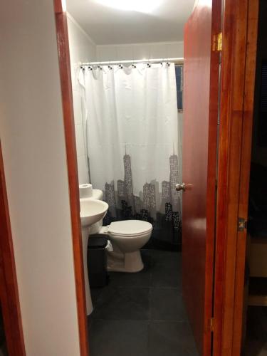 a bathroom with a toilet and a sink at Cabañas Costatour Quintero in Quintero