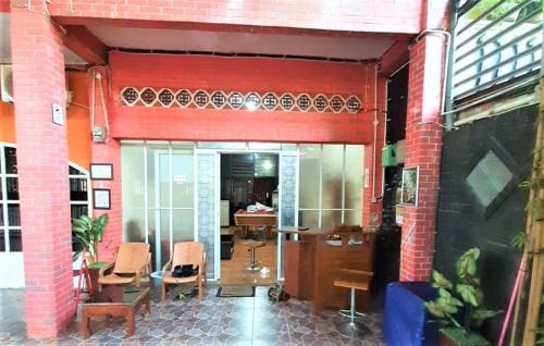 a red brick building with chairs and a table at Katawa Guest House Syariah in Sukarami