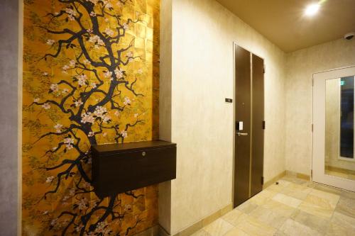 a bathroom with a wall mural of a tree with flowers at RoNa Hotel in Tokyo