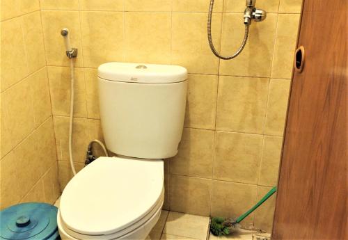 a bathroom with a toilet and a shower at Katawa Guest House Syariah in Sukarami