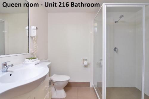 a bathroom with a toilet and a sink and a shower at The Newport on Macrossan - Adults Only in Port Douglas