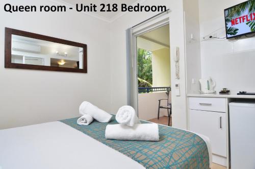 a bedroom with a bed with towels on it at The Newport on Macrossan - Adults Only in Port Douglas