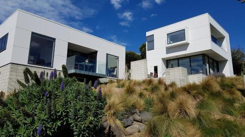 uma casa branca numa colina com plantas em The Rectangle Apartment, Akaroa em Akaroa