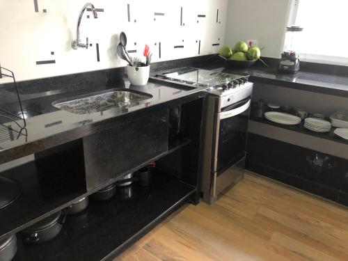 a kitchen with a sink and a stove at Condomínio Mar Verde Caraguatatuba - CASA 55 in Caraguatatuba