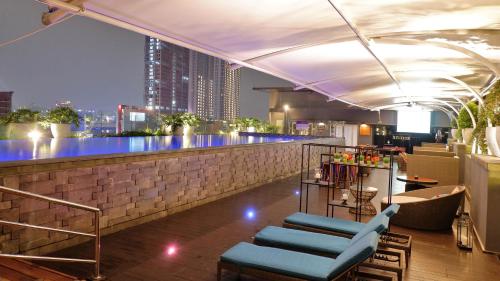 a bar at a nightclub with a view of a city at Mercure Jakarta Cikini in Jakarta