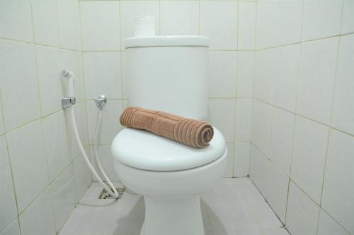 a bathroom with a toilet with a towel on it at Comfy Studio Poris 88 Apartment By Travelio in Poris-lor