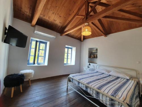 a bedroom with a bed and a flat screen tv at Diamoni Afroditi dogfriendly holidayhome with garden 2 to 5 persons in Karavás