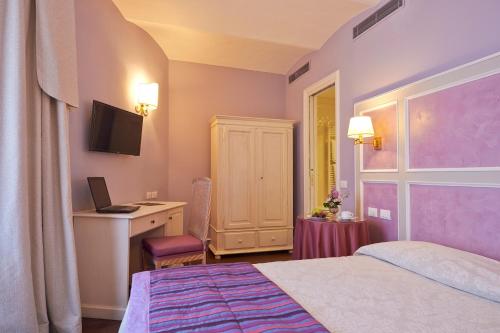 a bedroom with a bed and a desk with a computer at Hotel Firenze Capitale in Florence