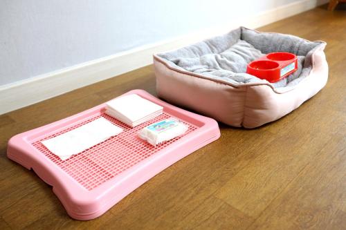 a pink dog bed sitting on a wooden floor at Yangji Pine Resort in Yongin