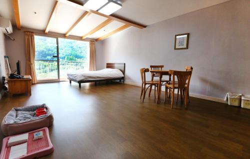 sala de estar con mesa, sillas y cama en Yangji Pine Resort, en Yongin