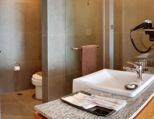 a bathroom with a sink and a toilet at Kokoon Hotel Banyuwangi in Banyuwangi