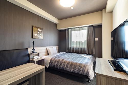 Postel nebo postele na pokoji v ubytování Hotel Route-Inn Kashiwa Minami -Kokudo 16Gouzoi-