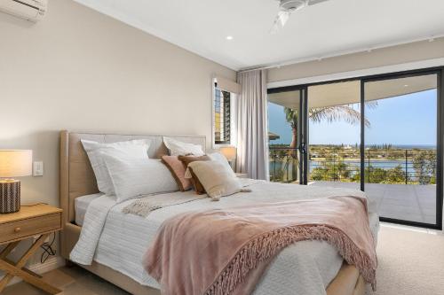 a bedroom with a bed with a view of the ocean at Shawhaven in East Ballina