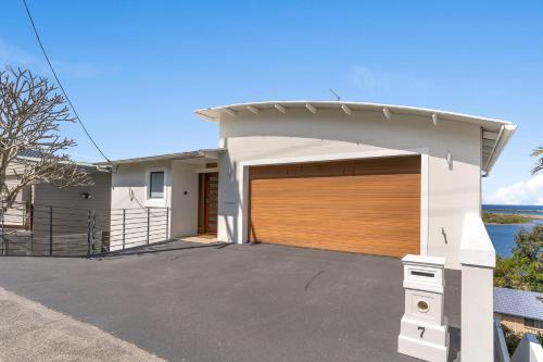 a detached garage with a wooden garage door at Shawhaven in East Ballina