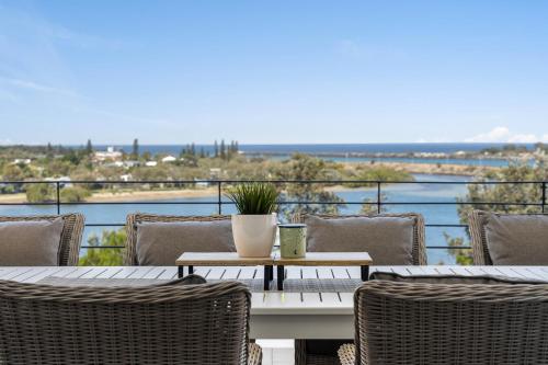 a table and chairs on a balcony with a view of the water at Shawhaven in East Ballina