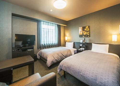 Cette chambre comprend 2 lits et une télévision à écran plat. dans l'établissement Hotel Route-Inn Katori Sawara Ekimae, à Katori