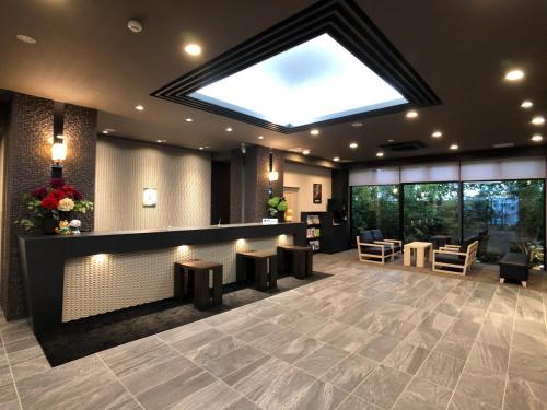a lobby with a large skylight in the ceiling at Hotel Route-Inn Grand Ota Ekimae in Ota