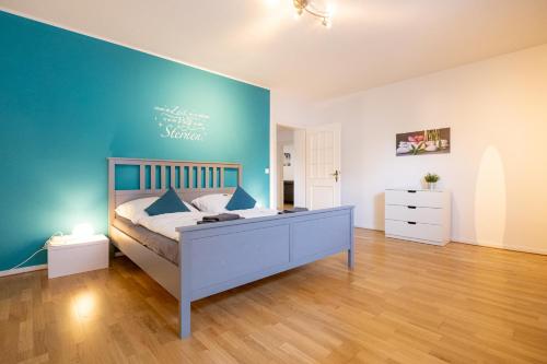 a bedroom with a bed and a blue wall at Ferienwohnung zum Wohlfühlen in Essen