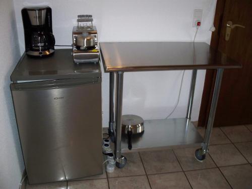 een tafel met een koffiezetapparaat bovenop een koelkast bij 2 Raum Wohnung in Krefeld