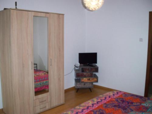 1 dormitorio con una puerta que conduce a una cama y TV en 2 Raum Wohnung en Krefeld