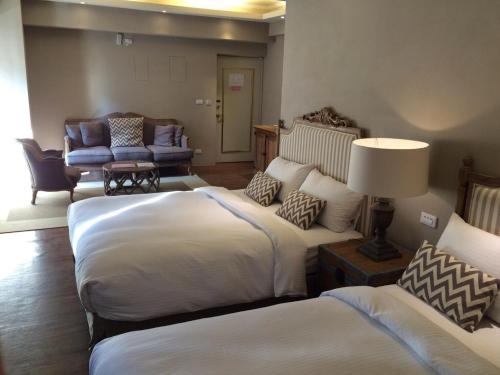 a hotel room with two beds and a couch at Chihpen Hotel Royal Kingdom in Wenquan