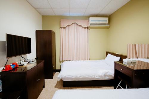 a hotel room with two beds and a television at 金鷺民宿 in Jincheng