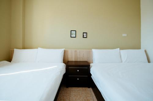 two beds sitting next to each other in a room at 金鷺民宿 in Jincheng