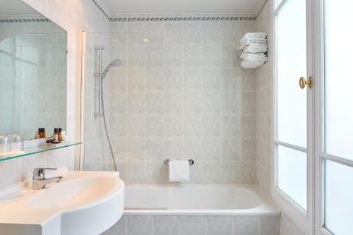 a bathroom with a sink and a bath tub at Hotel De La Jatte in Neuilly-sur-Seine