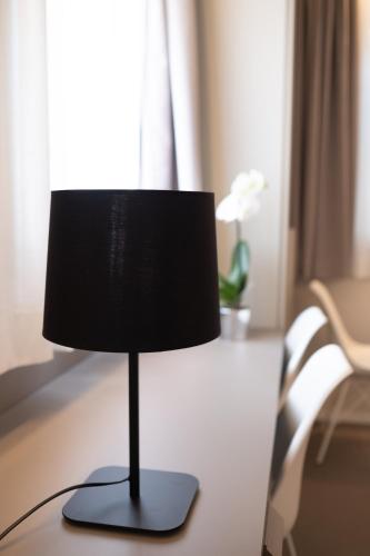 a black lamp sitting on a table in a room at Zeta T Rooms in Castellarano
