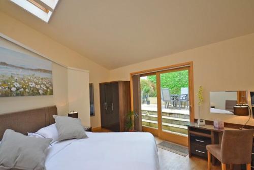 a bedroom with a bed and a desk and a window at Silvergrove Apartment in E Sussex in Newick