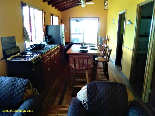 a kitchen with a stove and a kitchen with a table at Fully equipped 2 bedroom tree top cottage, with large balcony in private garden in San Ignacio
