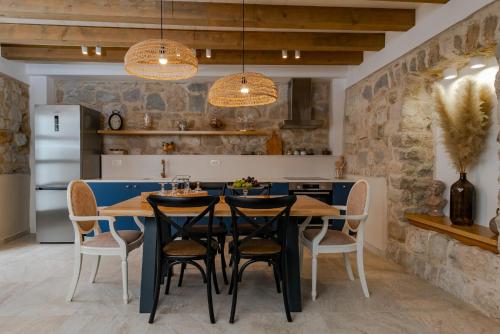 een keuken met een zwarte tafel en stoelen bij Villa Bante - Luxury Stone House in Kaštela
