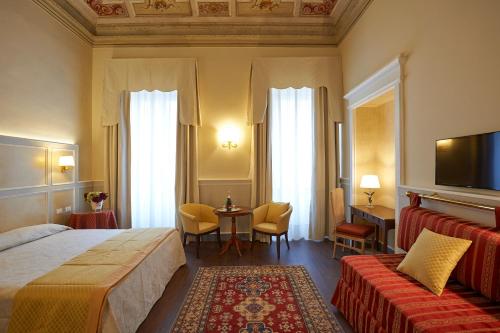 um quarto de hotel com uma cama e uma mesa com cadeiras em Hotel Firenze Capitale em Florença
