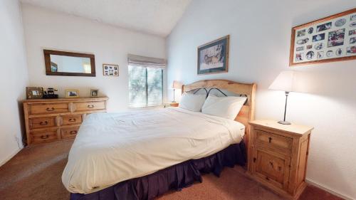 - une chambre avec un grand lit et une tête de lit en bois dans l'établissement Mammoth Reservations, à Mammoth Lakes