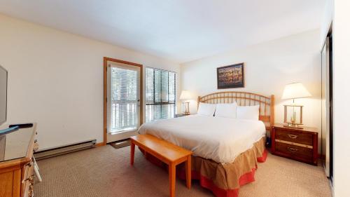a bedroom with a bed and a tv and windows at Mammoth Reservations in Mammoth Lakes