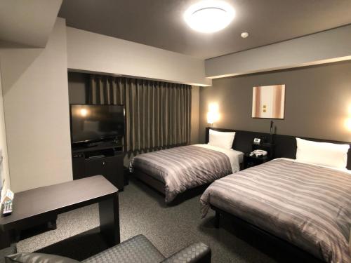 מיטה או מיטות בחדר ב-Hotel Route-Inn Grand Ota Ekimae