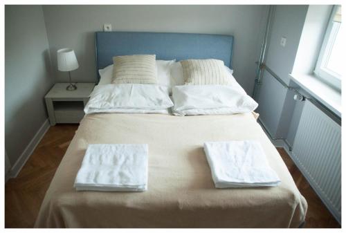 a bed with two towels sitting on top of it at Color 24 Apartament III in Stalowa Wola