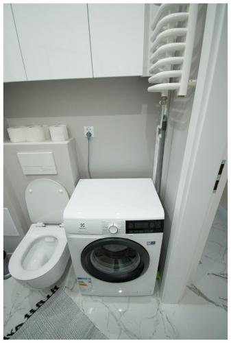a washing machine in a bathroom with a toilet at Color 24 Apartament III in Stalowa Wola
