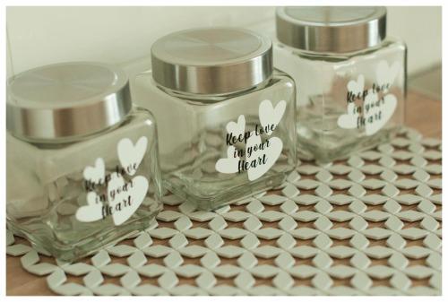 three glass jars sitting on top of a table at Color 24 Apartament III in Stalowa Wola
