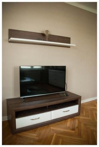 a flat screen tv sitting on top of a tv stand at Color 24 Apartament III in Stalowa Wola