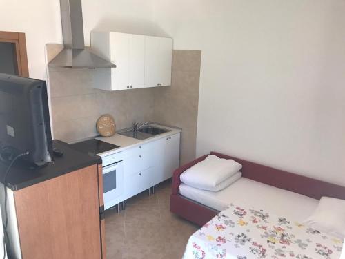 a small room with a small kitchen and a bed at Casa Santa Maria in Folgaria
