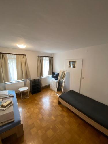 a bedroom with a bed and a living room at Einfaches Haus mit Privatzimmern und Gemeinschaftsräumen in Heilbronn