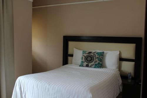 a bed with a white comforter and a pillow at Hotel Cacaxtla in La Concordia